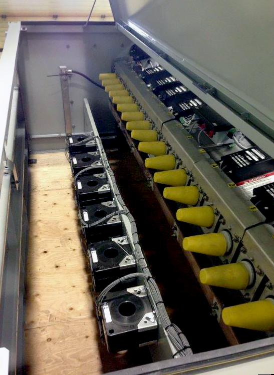 The inside of a Remote-Supervisory Vista® Underground Distribution Switchgear unit. The unit's top is open. On the right, bushings are covered with yellow caps. Below and to the left, six ways lie on the "floor" level.